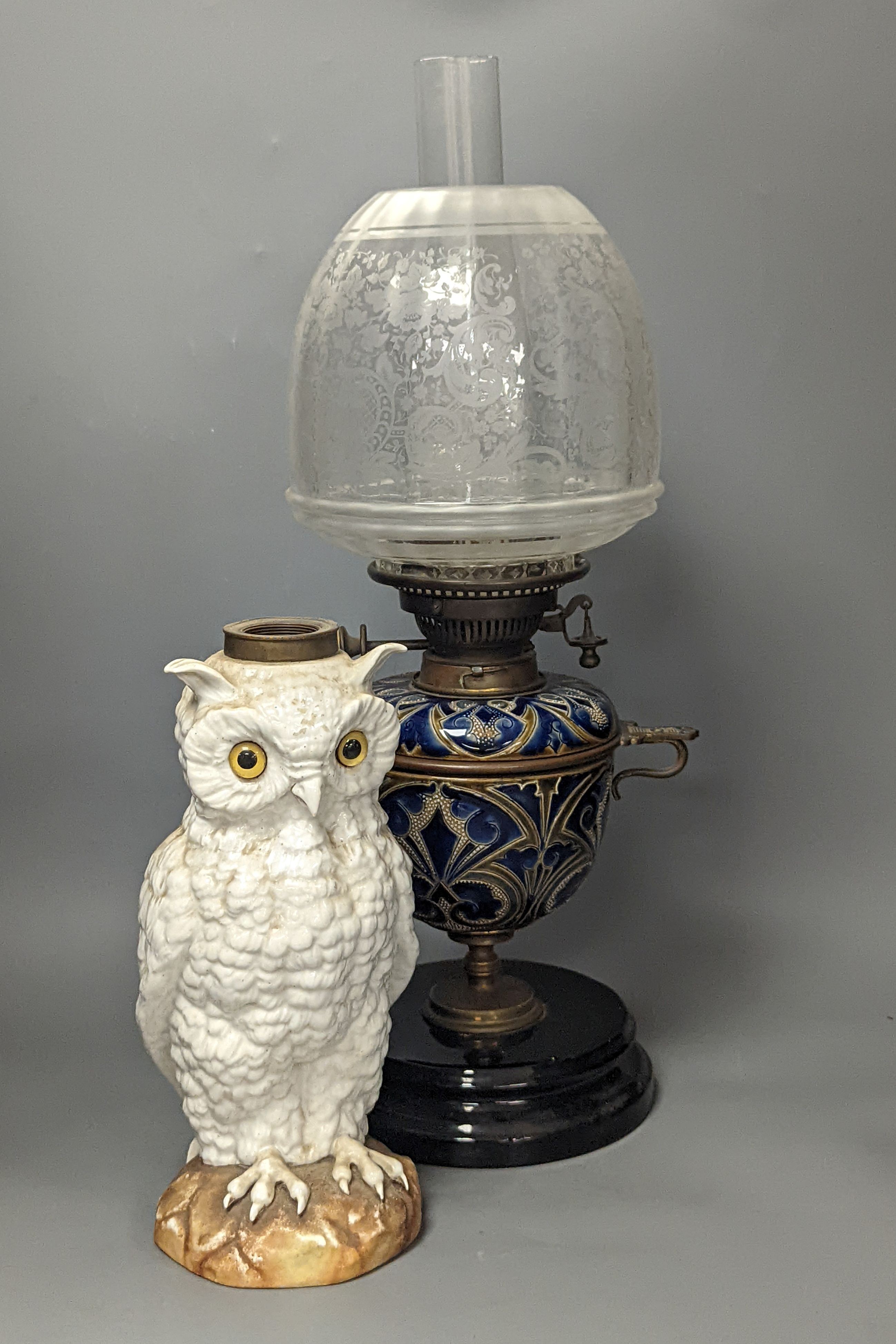 A Doulton Lambeth stoneware oil lamp and a German porcelain’owl’ lamp base, Oil lamp 54 cms high including funnel.